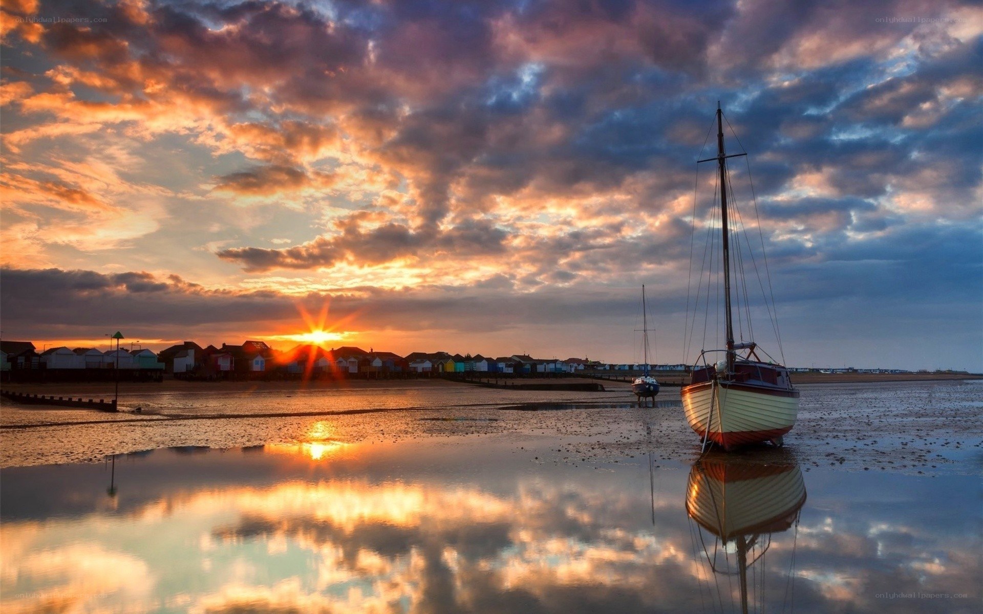 Sunset over a beach with boats