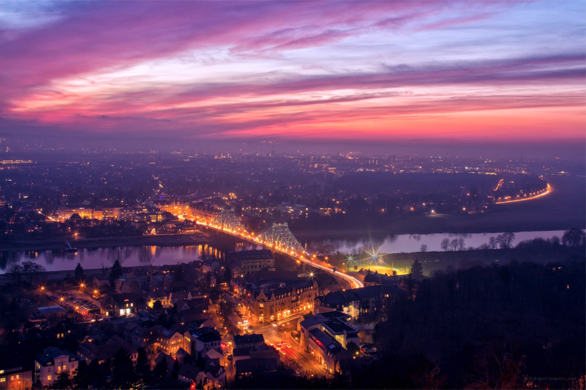 Sunset over a city with a bridge