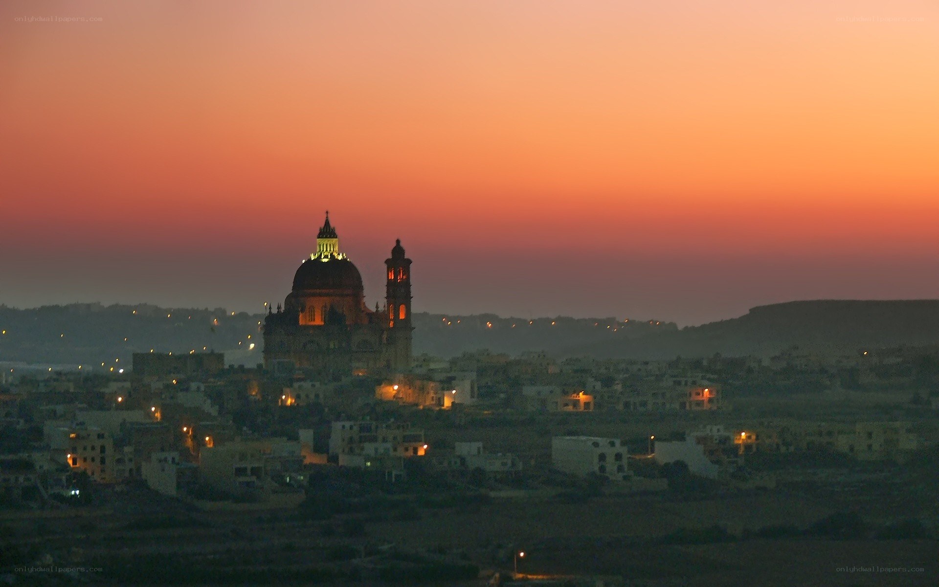 sunset over a city with cathedral