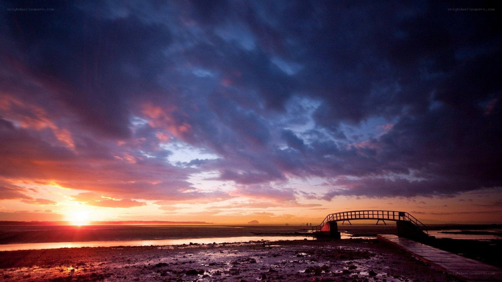 sunset over a coastal bridge