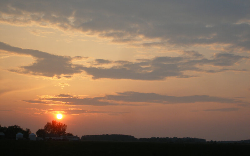 sunset over a farm field