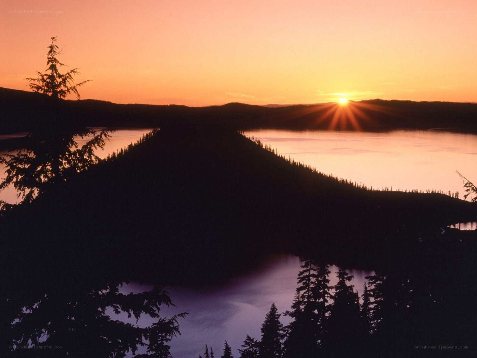 sunset over a forested lake