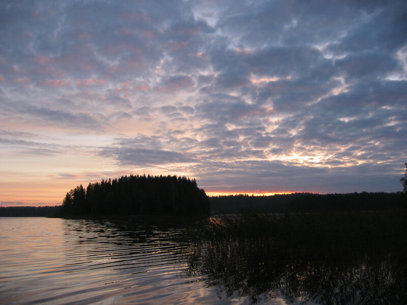 Sunset over a forested lake