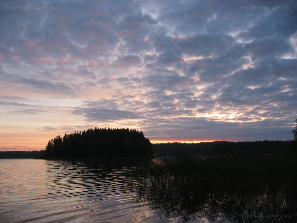 Sunset over a forested lake