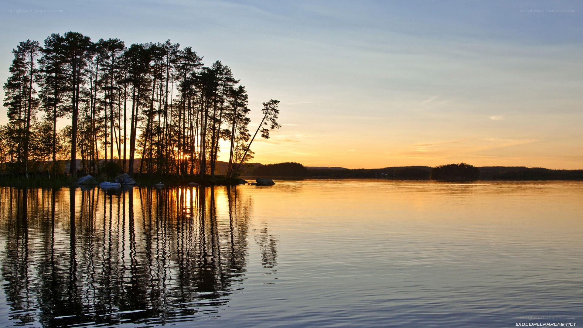 sunset over a forested lake