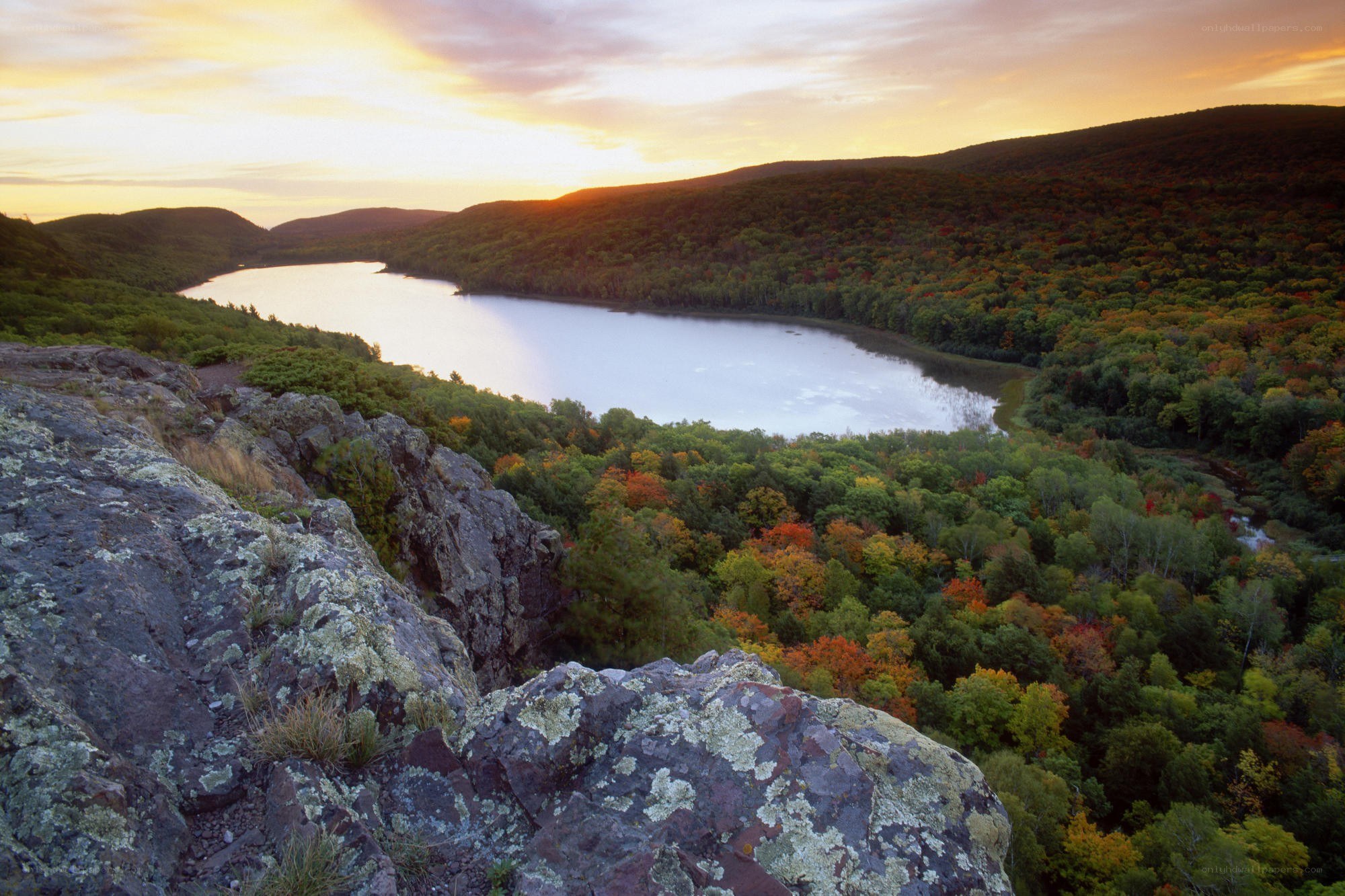 sunset over a forested lake