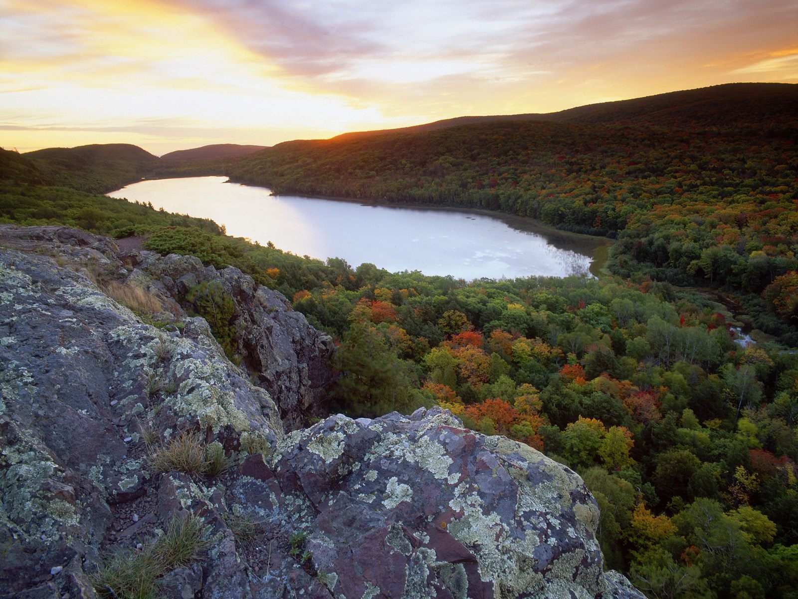 sunset over a forested lake