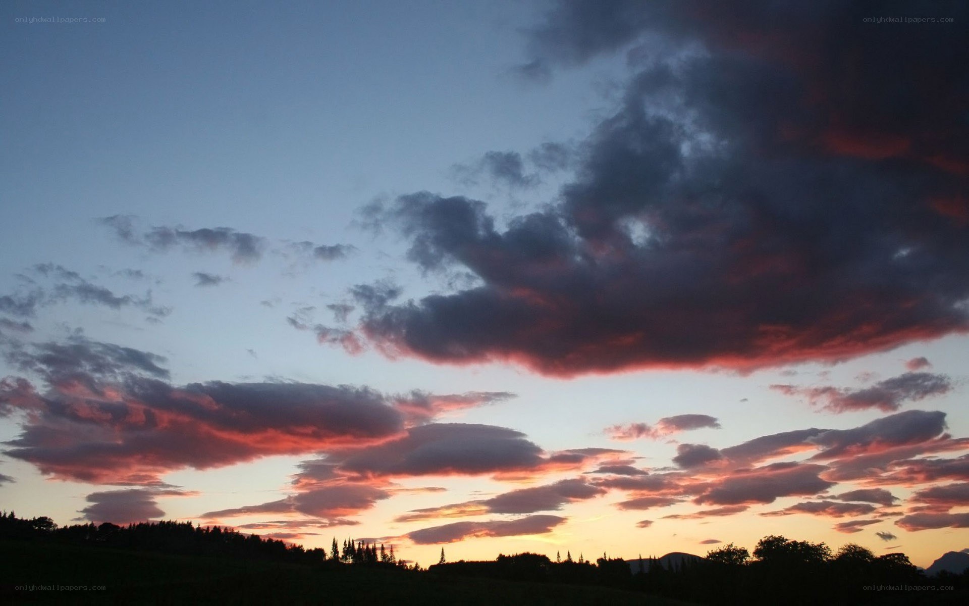 sunset over a forested landscape