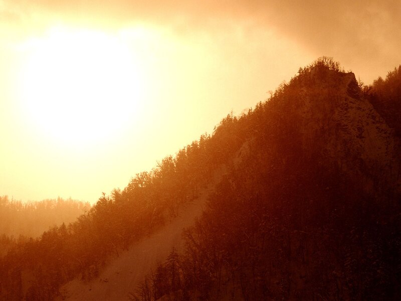 Sunset over a forested mountain