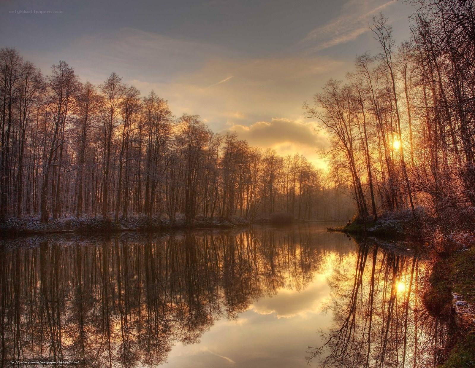 Sunset over a frozen forest lake