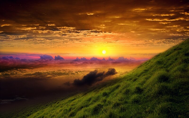 Sunset over a green hill