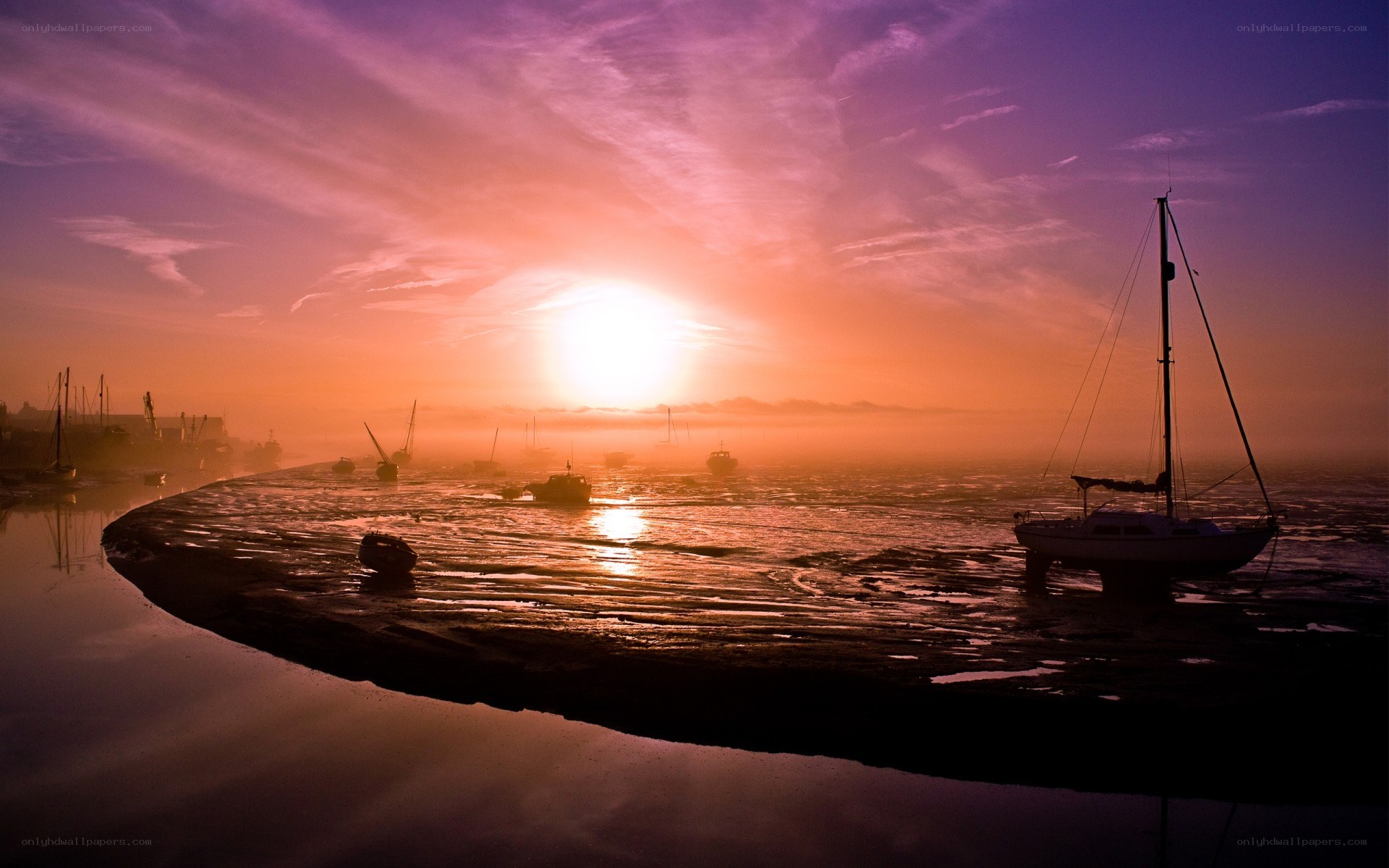 Sunset over a harbor at low tide