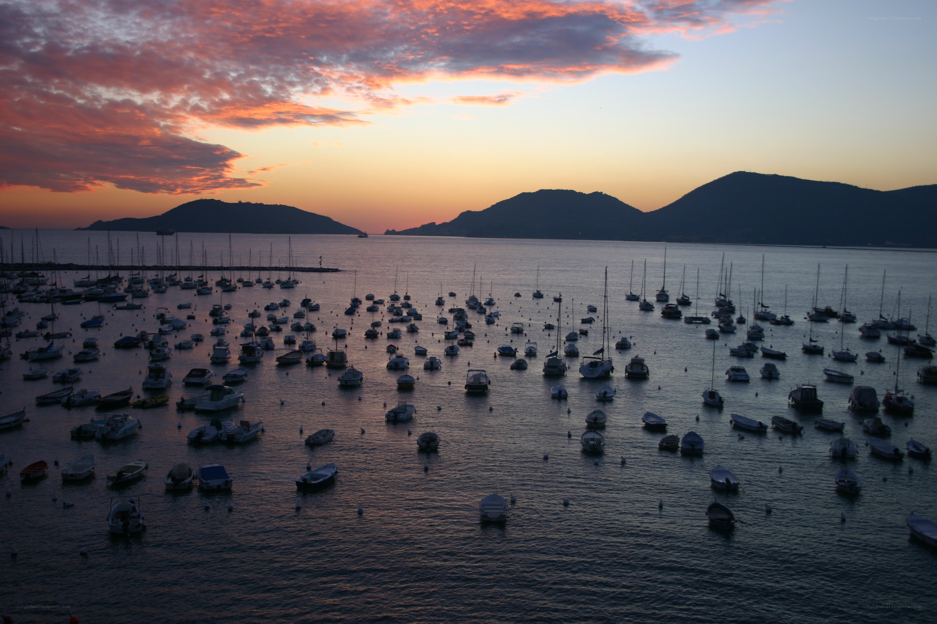 Sunset over a harbor with boats