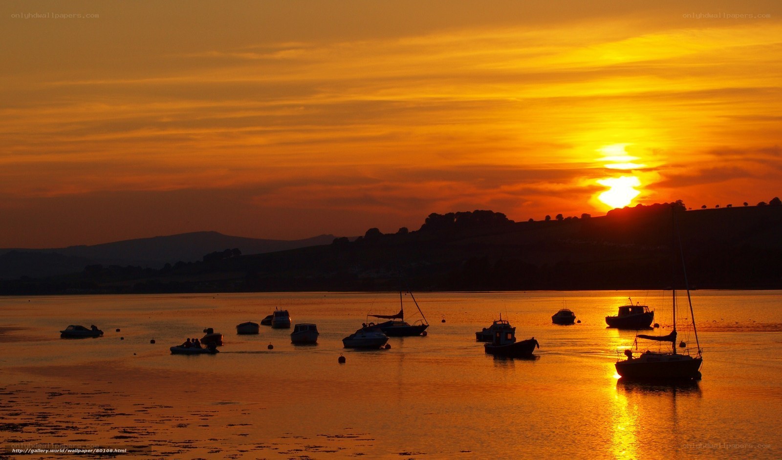 Sunset over a harbor with boats