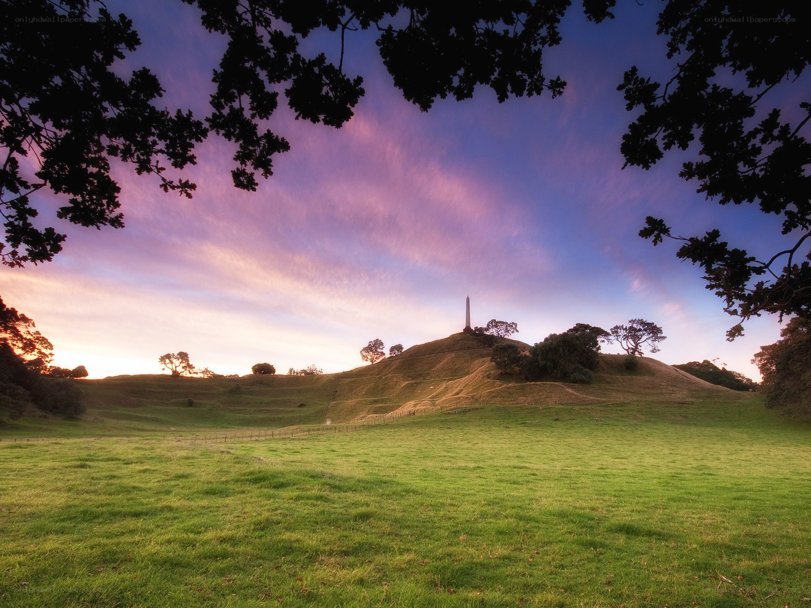 Sunset over a hill with obelisk