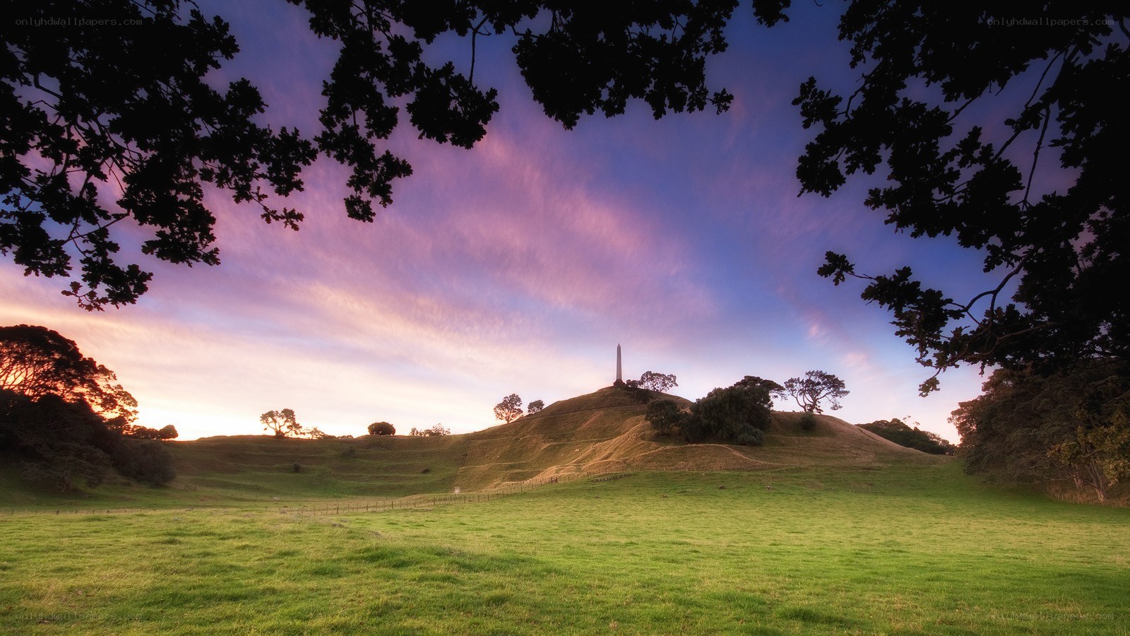 Sunset over a hill with obelisk