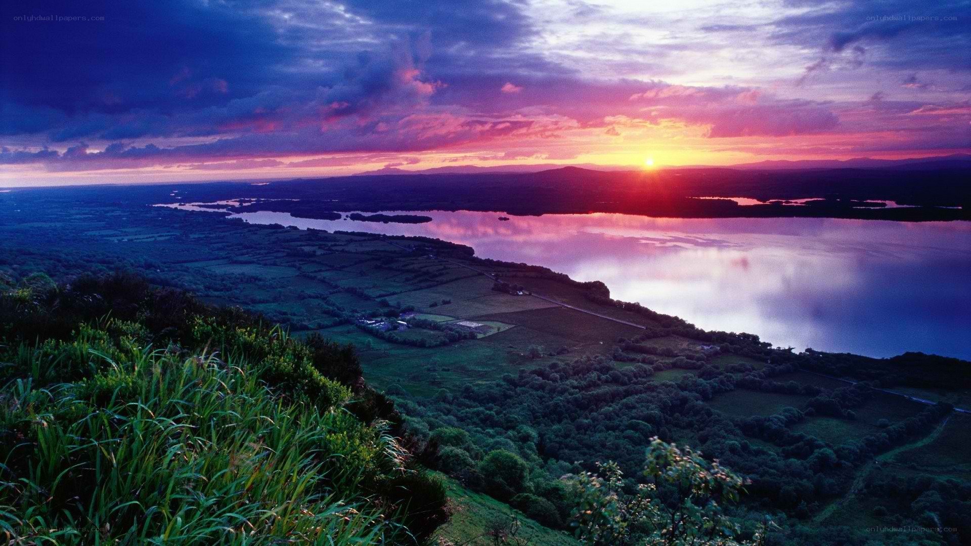 sunset over a lake and fields