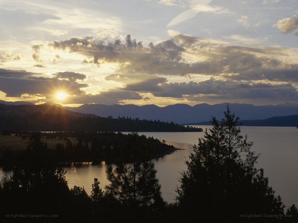 sunset over a lake and mountains