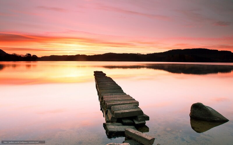 Sunset over a lake with a pier