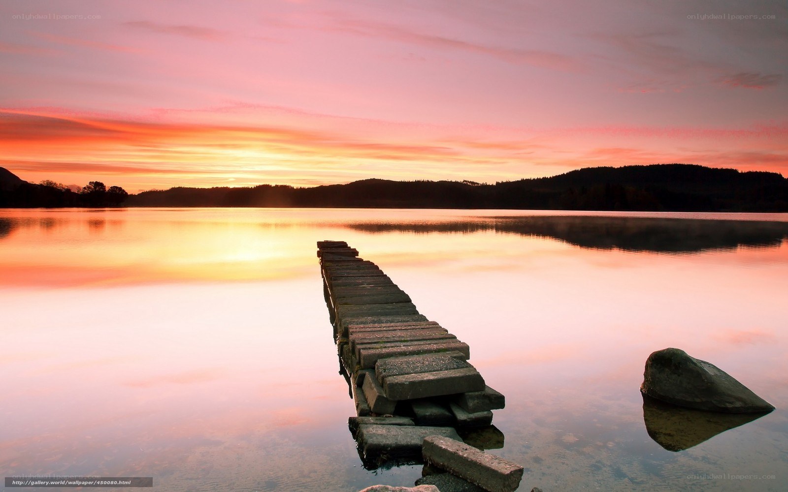 Sunset over a lake with a pier