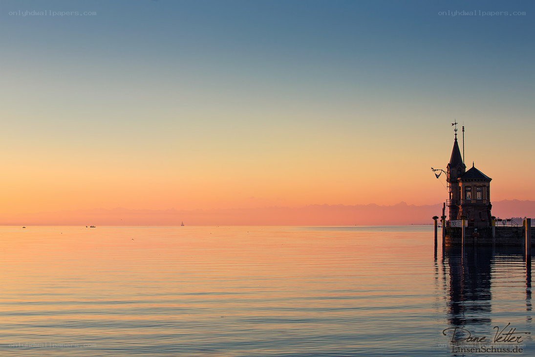 Sunset over a lake with a tower