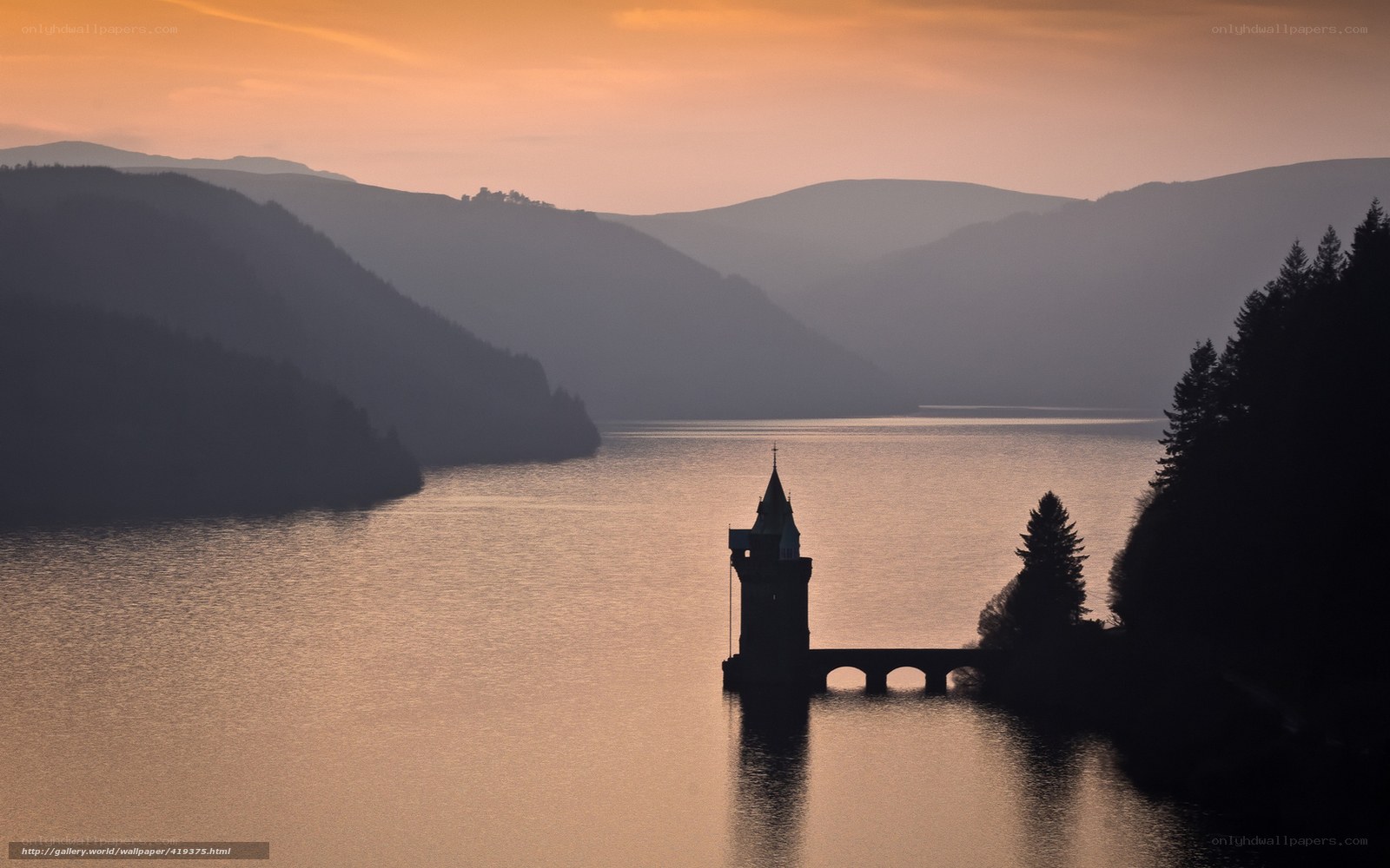 Sunset over a lake with a tower