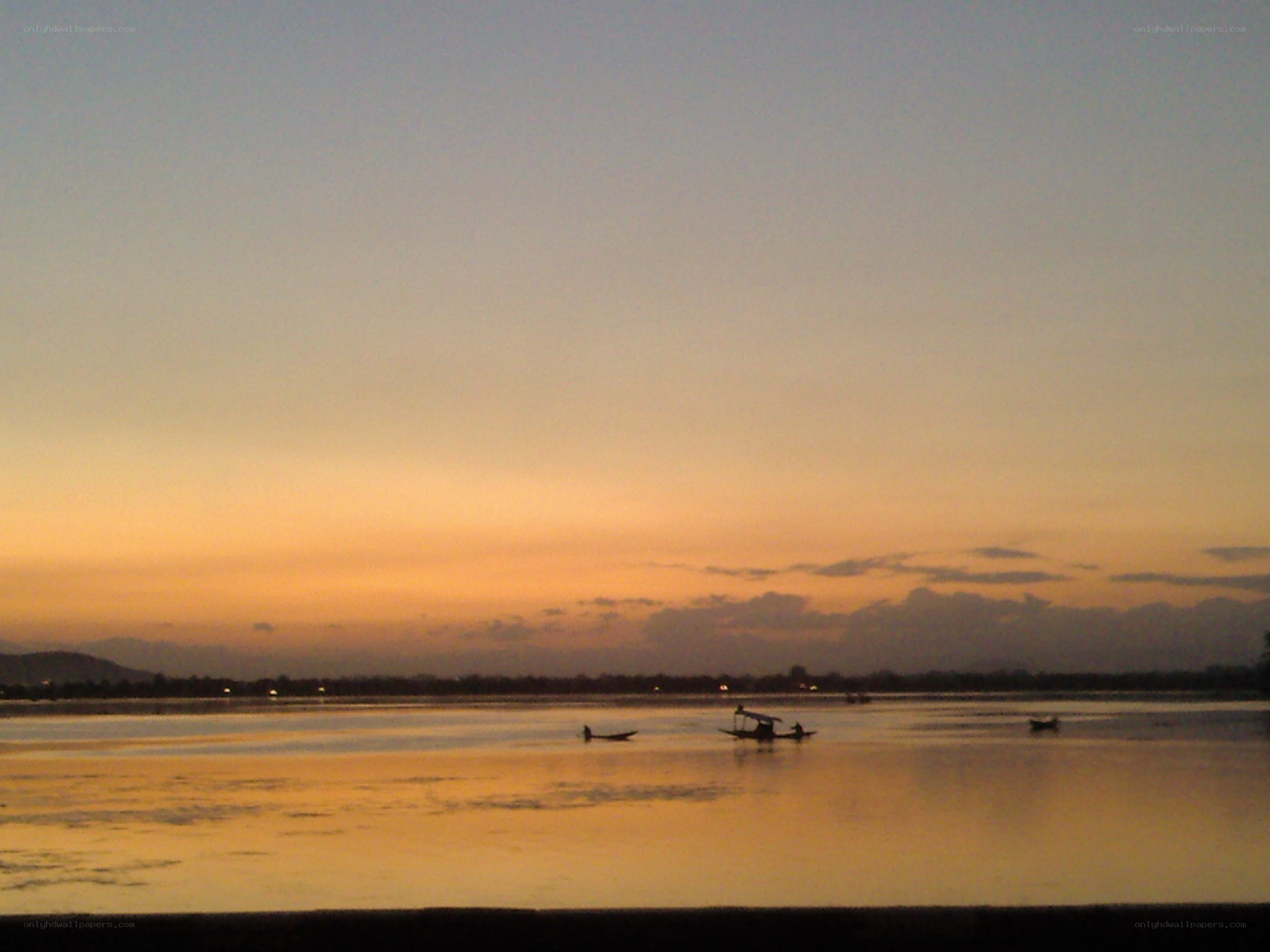sunset over a lake with boats
