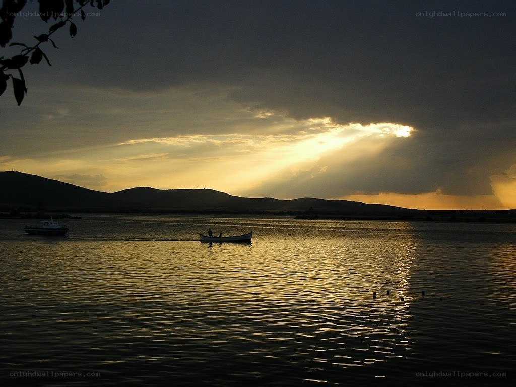 Sunset over a lake with boats