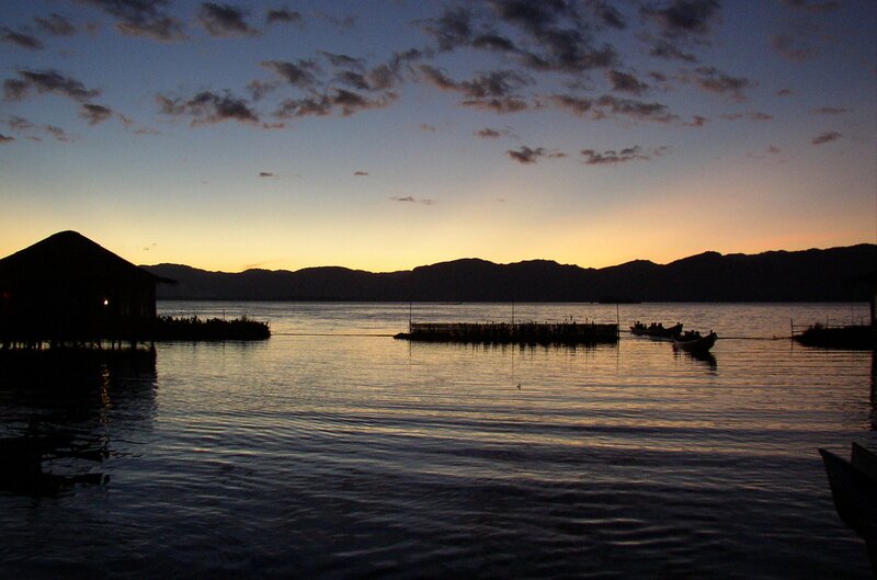 sunset over a lake with boats