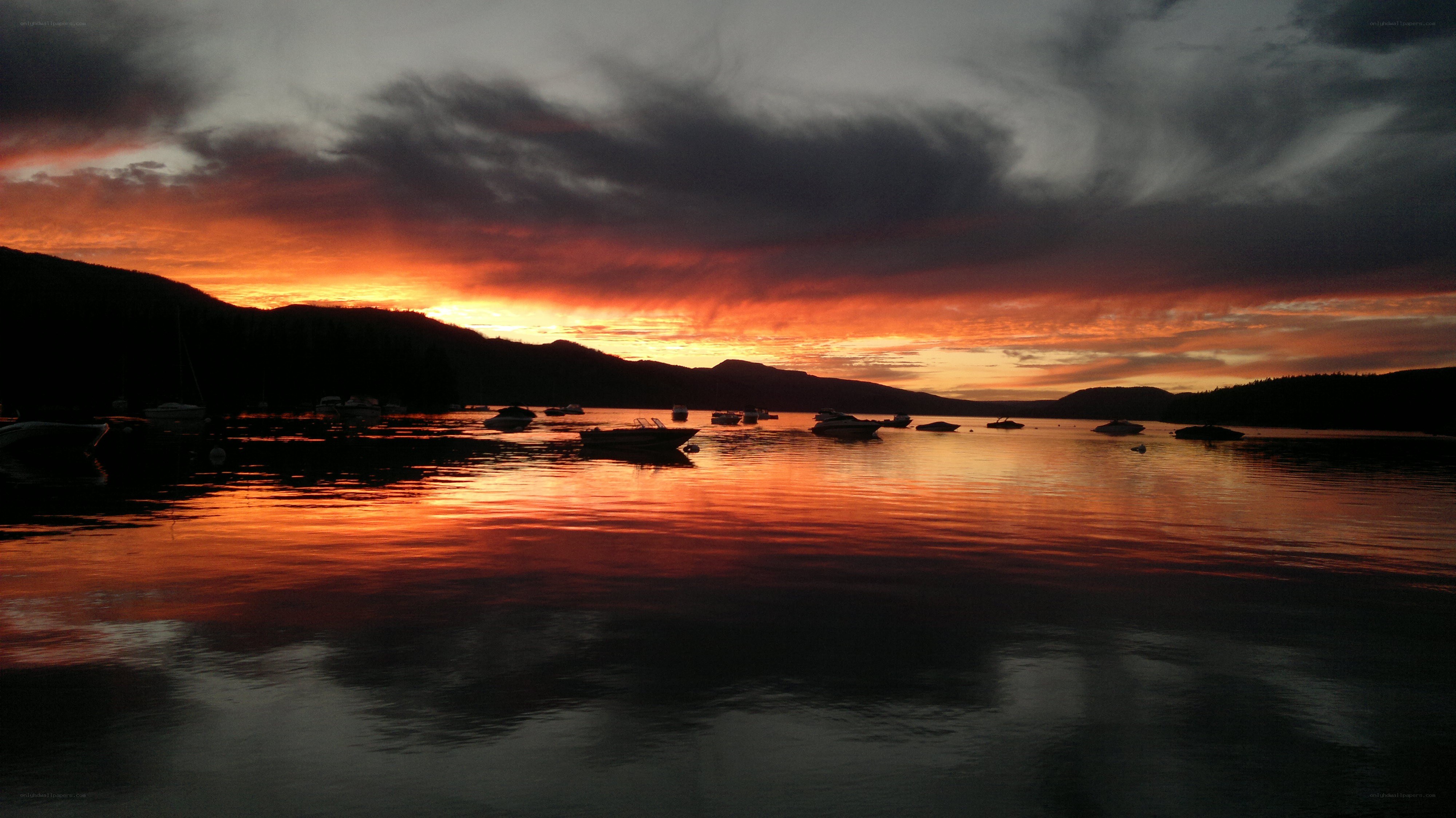 sunset over a lake with boats