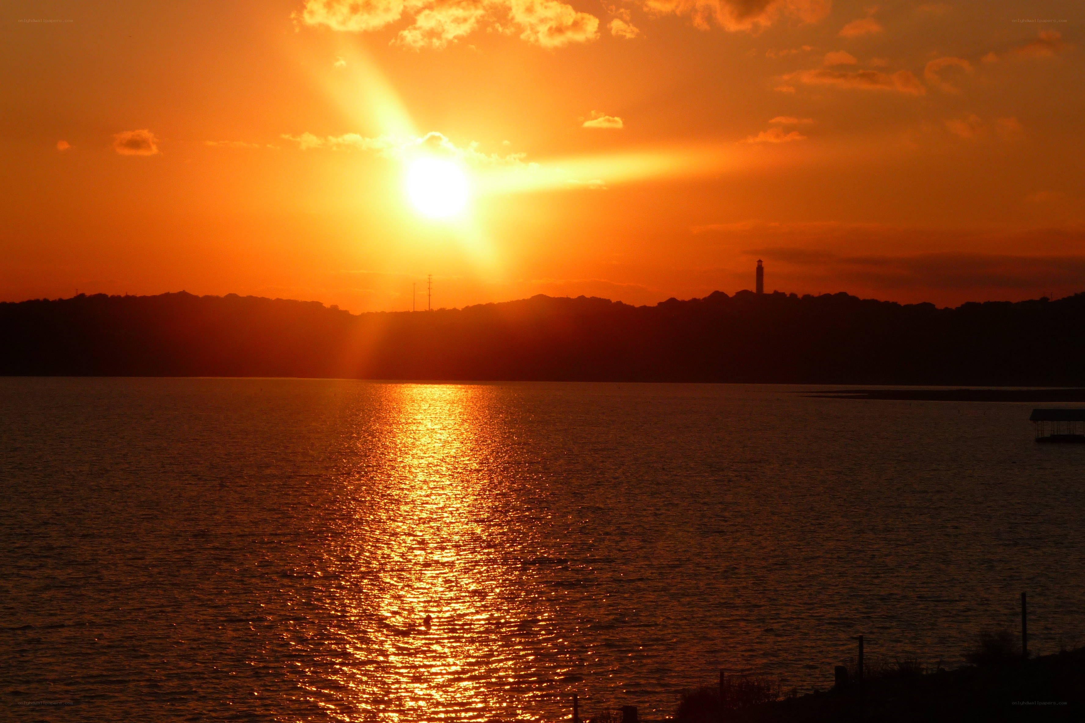 Sunset over a lake with lighthouse
