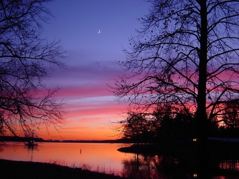 sunset over a lake with moon