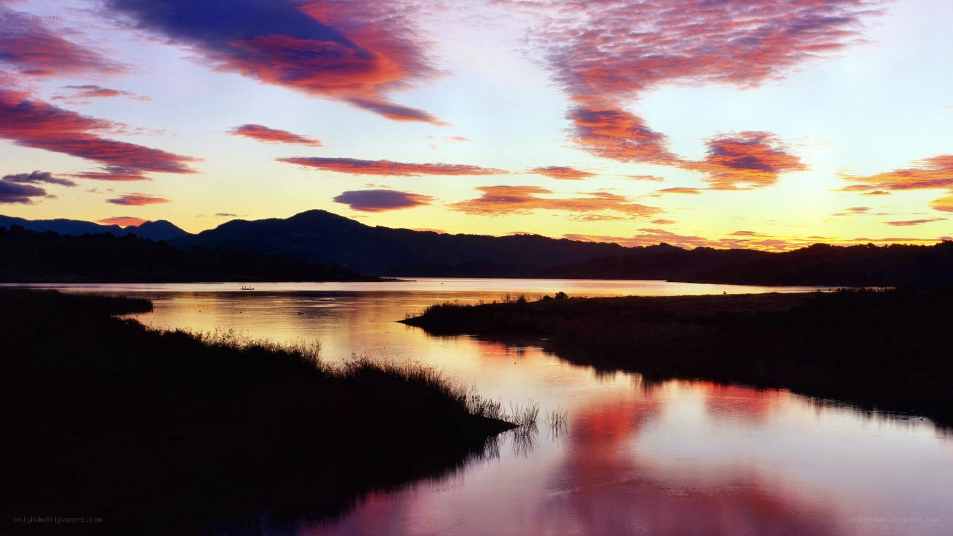 sunset over a lake with mountains