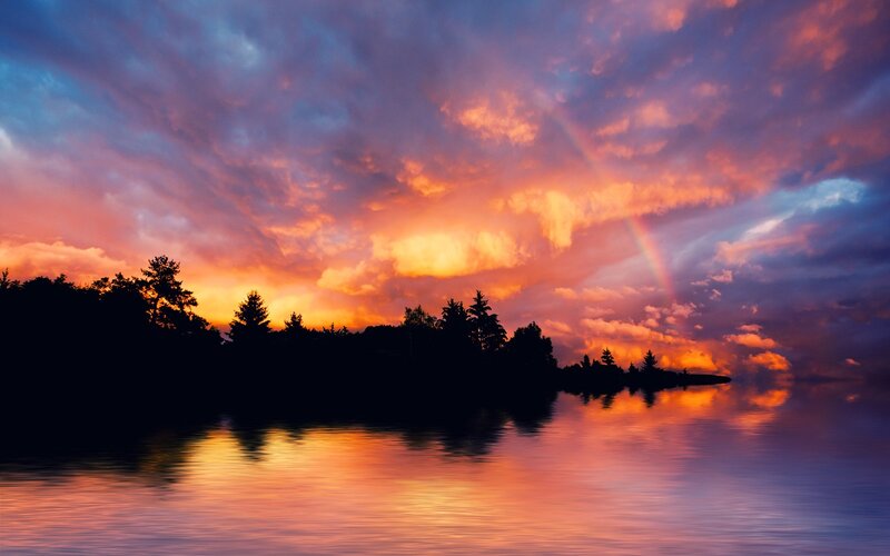 Sunset over a lake with rainbow