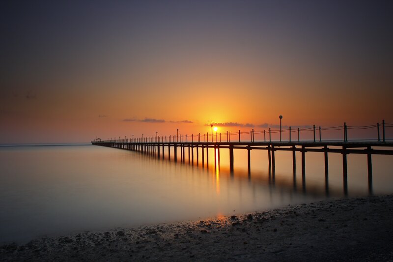 Sunset over a long pier