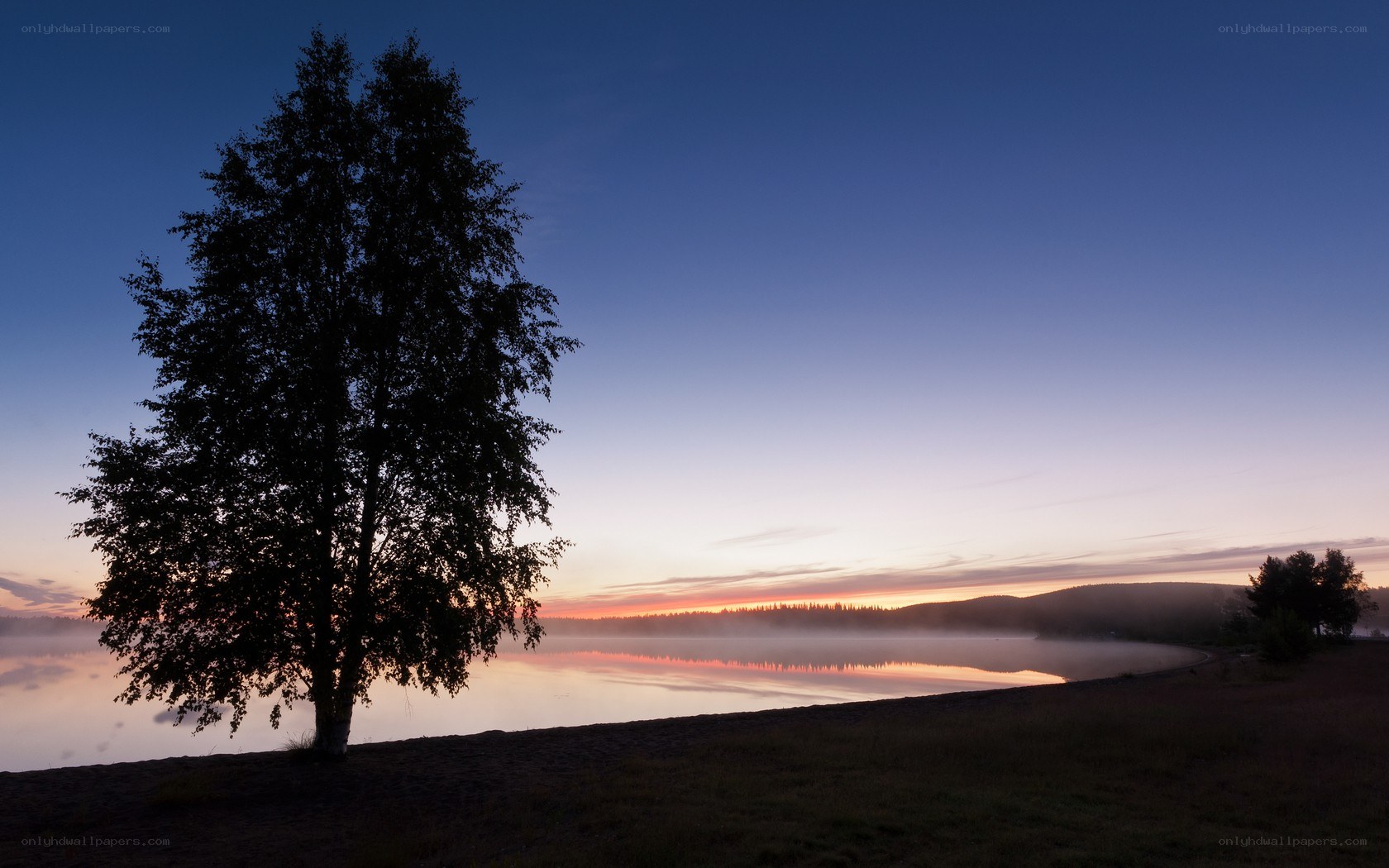 sunset over a misty lake
