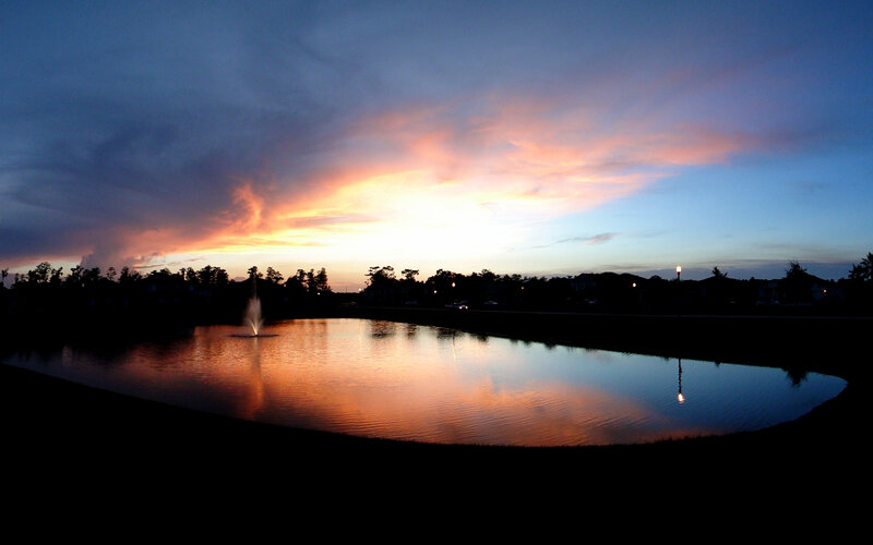 sunset over a pond with fountain