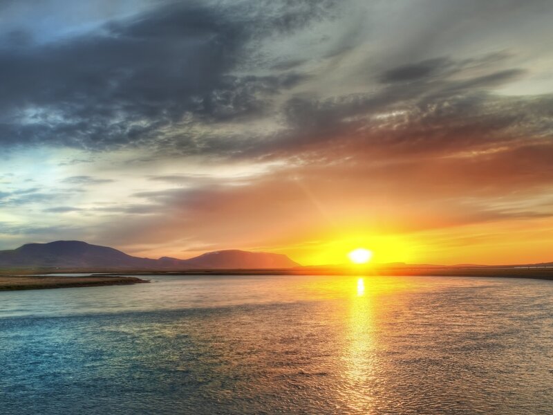 Sunset over a river and mountains