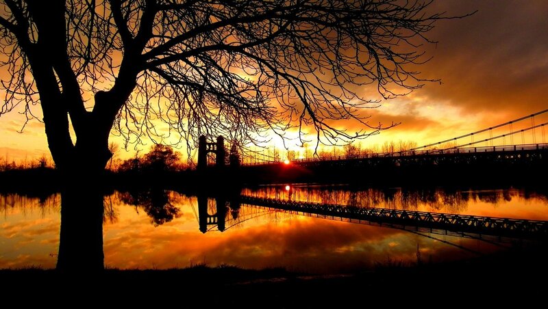 Sunset over a river bridge