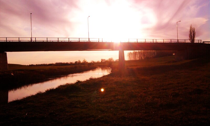 Sunset over a river bridge