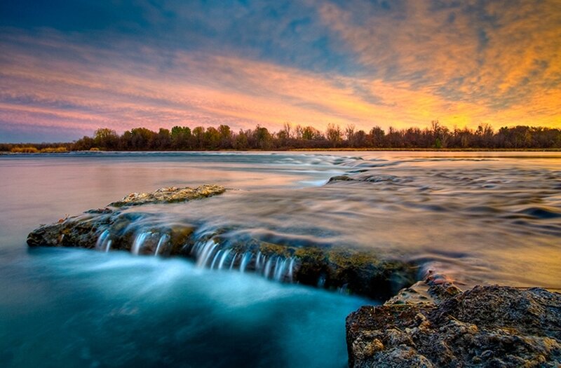 Sunset over a river waterfall