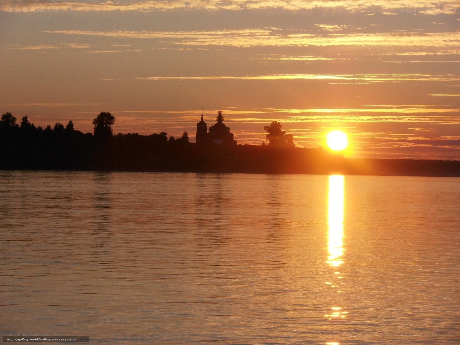 Sunset over a river with a church