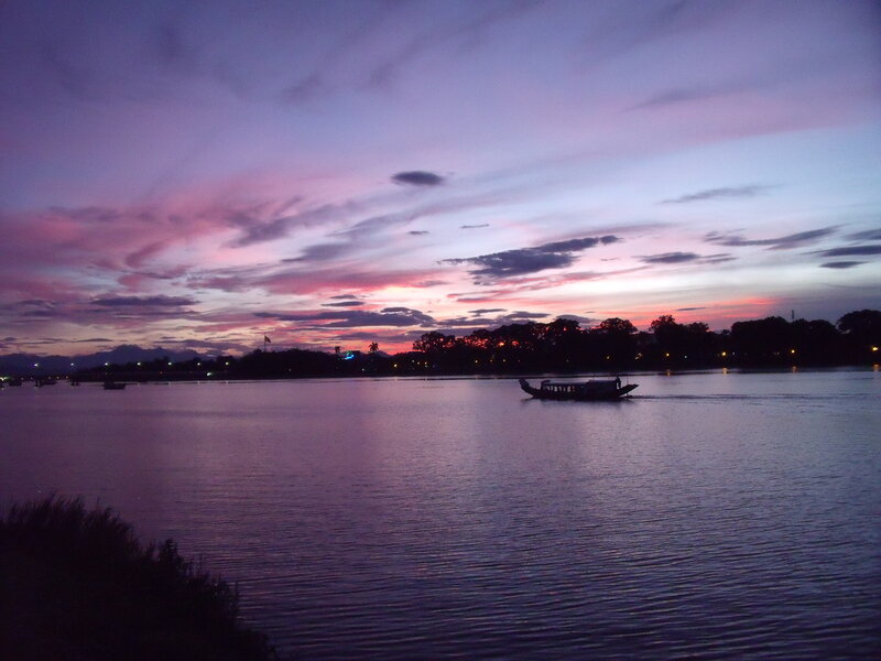 Sunset over a river with boats