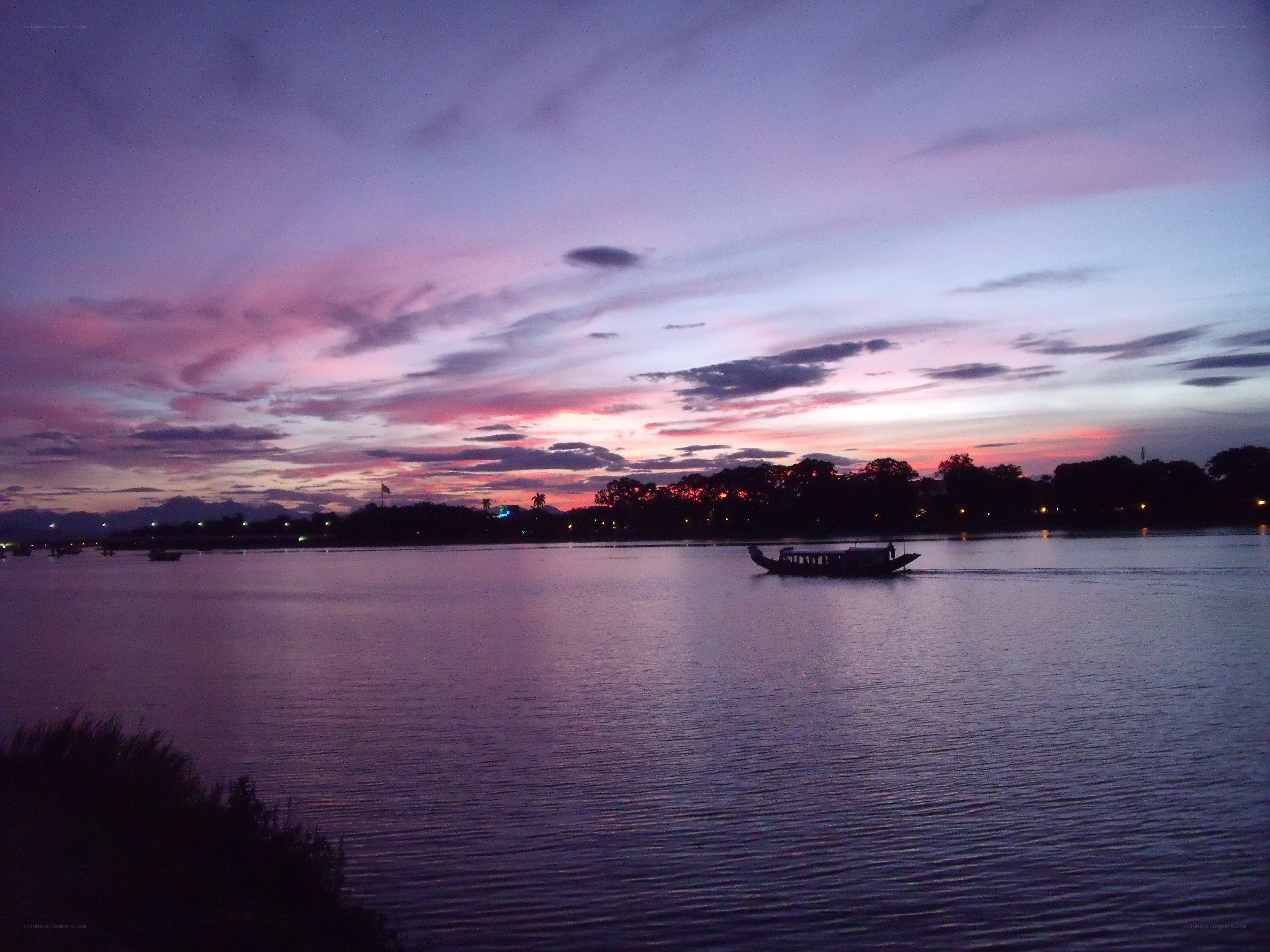 Sunset over a river with boats