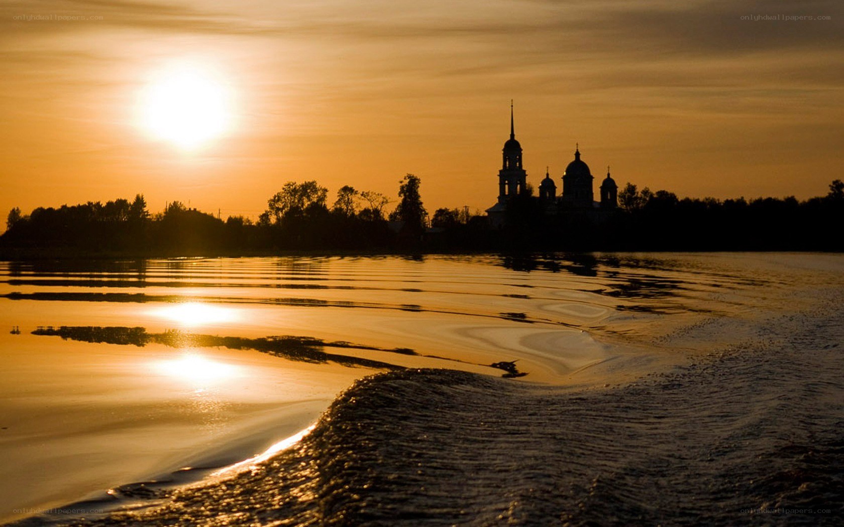 Sunset over a river with church