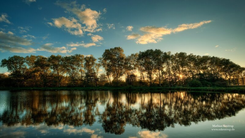 Sunset over a river with trees