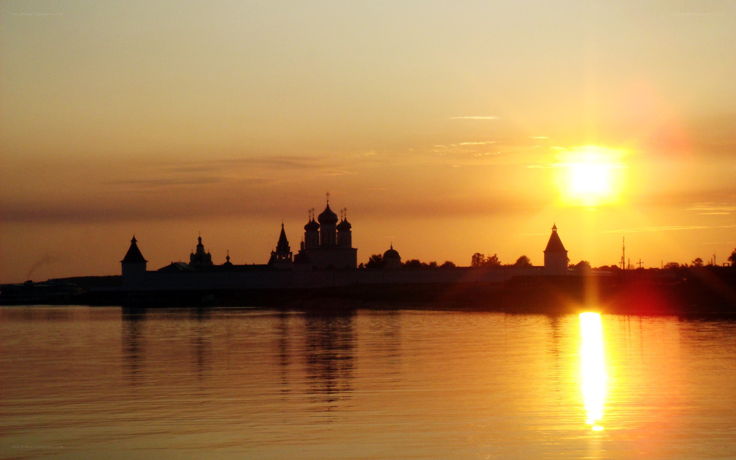 sunset over a riverside monastery