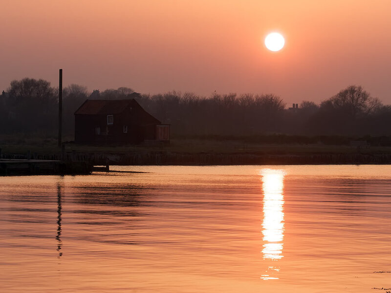 sunset over a riverside shed