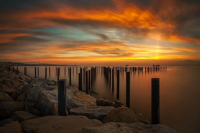 Sunset over a rocky pier