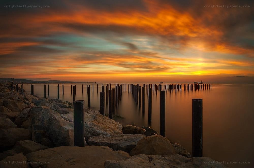 Sunset over a rocky pier